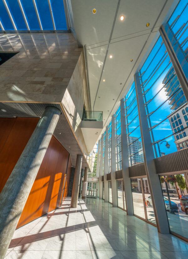 Modern commercial building with large windows, exposed columns and a feature orange wall.