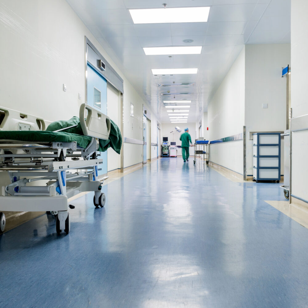 NHS hospital corridor with staff members walking through.