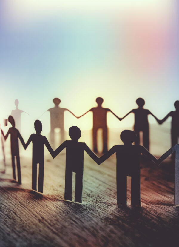 Paper cut outs of people standing in circle symbolising community