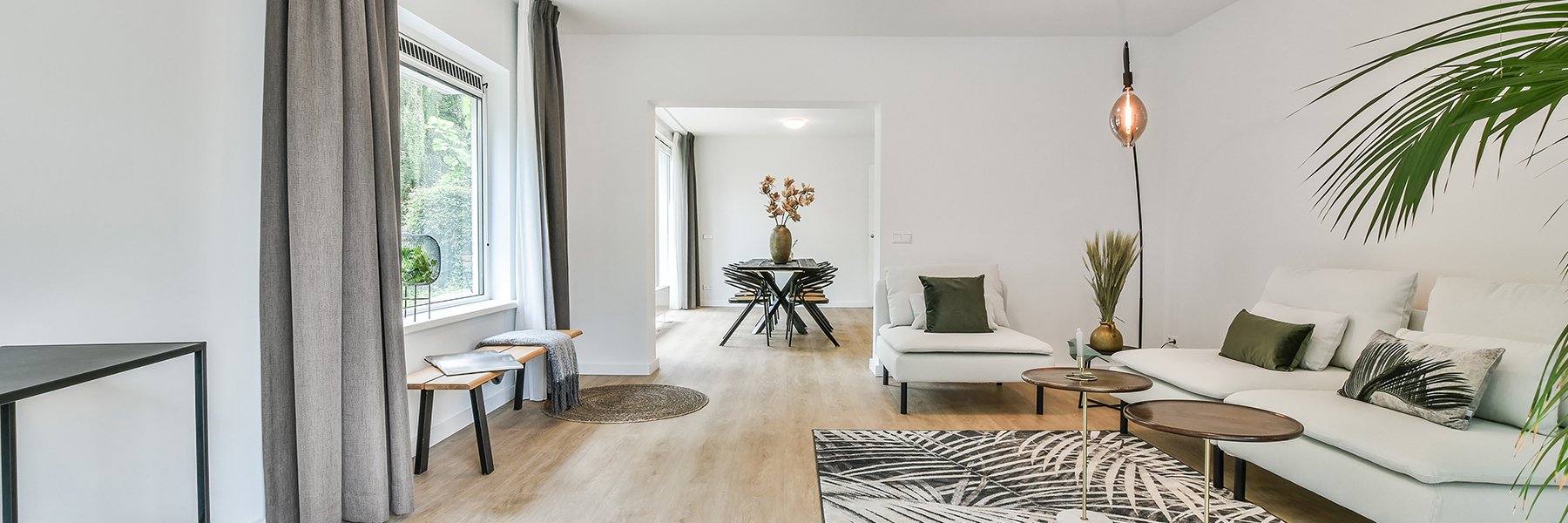 Internal of luxury house with white walls and sofas and laminate flooring.